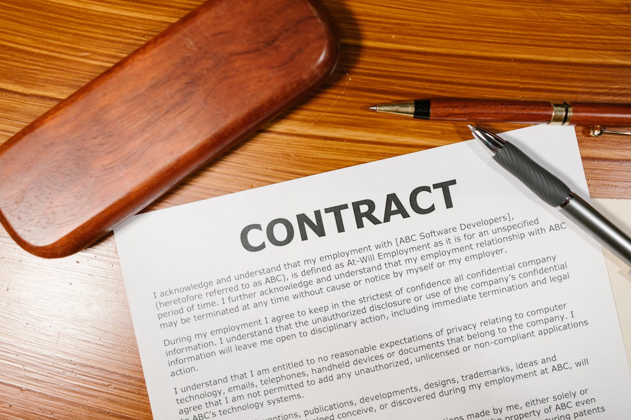 gallery-03 A close-up view of a contract and pen on a wooden desk, ideal for business themes.