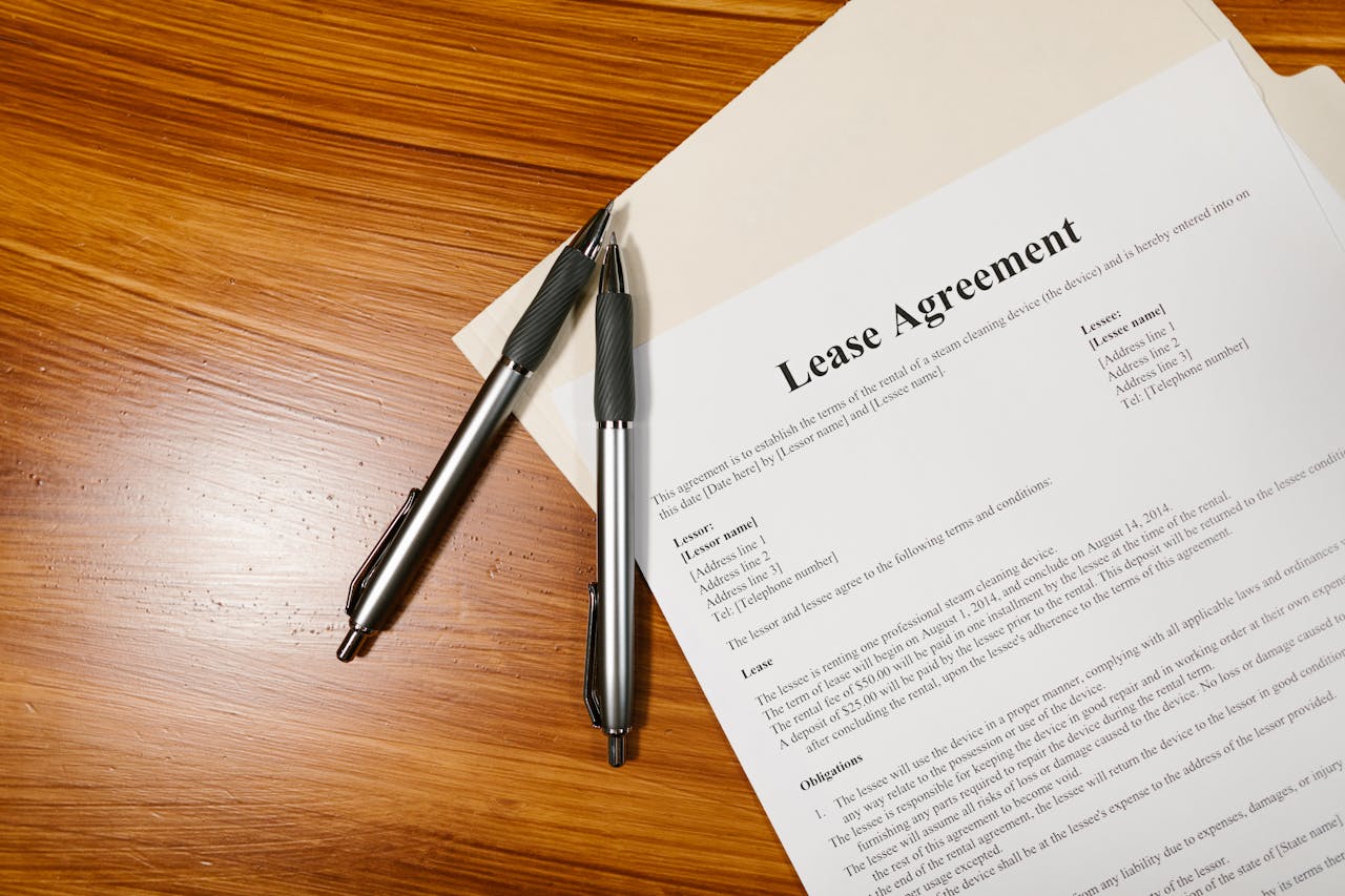 gallery-05 High-angle view of a lease agreement and pens on a wooden desk.